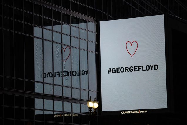 A digital sign overlooking protests in downtown Boston that reads "George Floyd" with a heart above the text