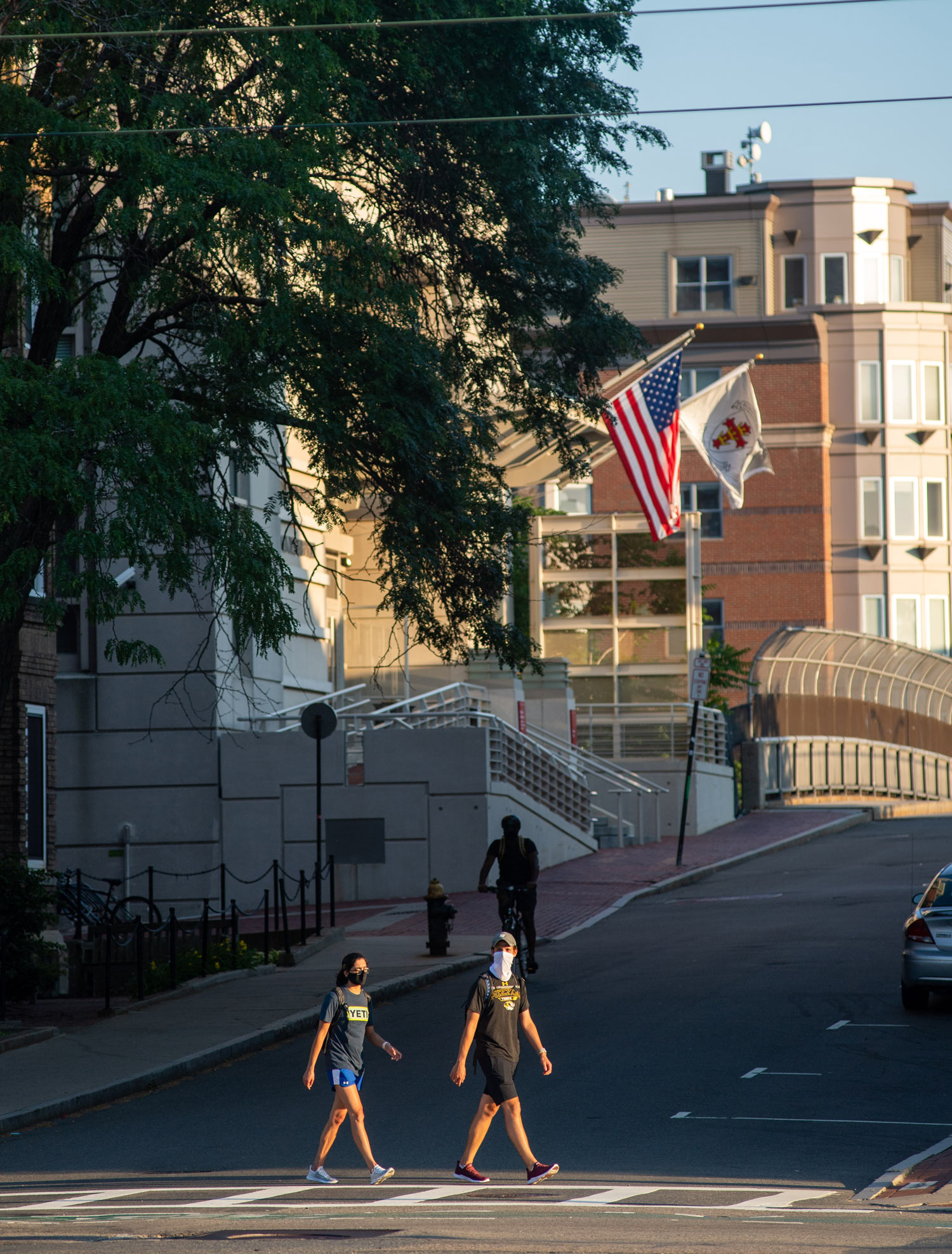 A photo of two people wearing masks walking down Commonwealth Avenue during the summer months