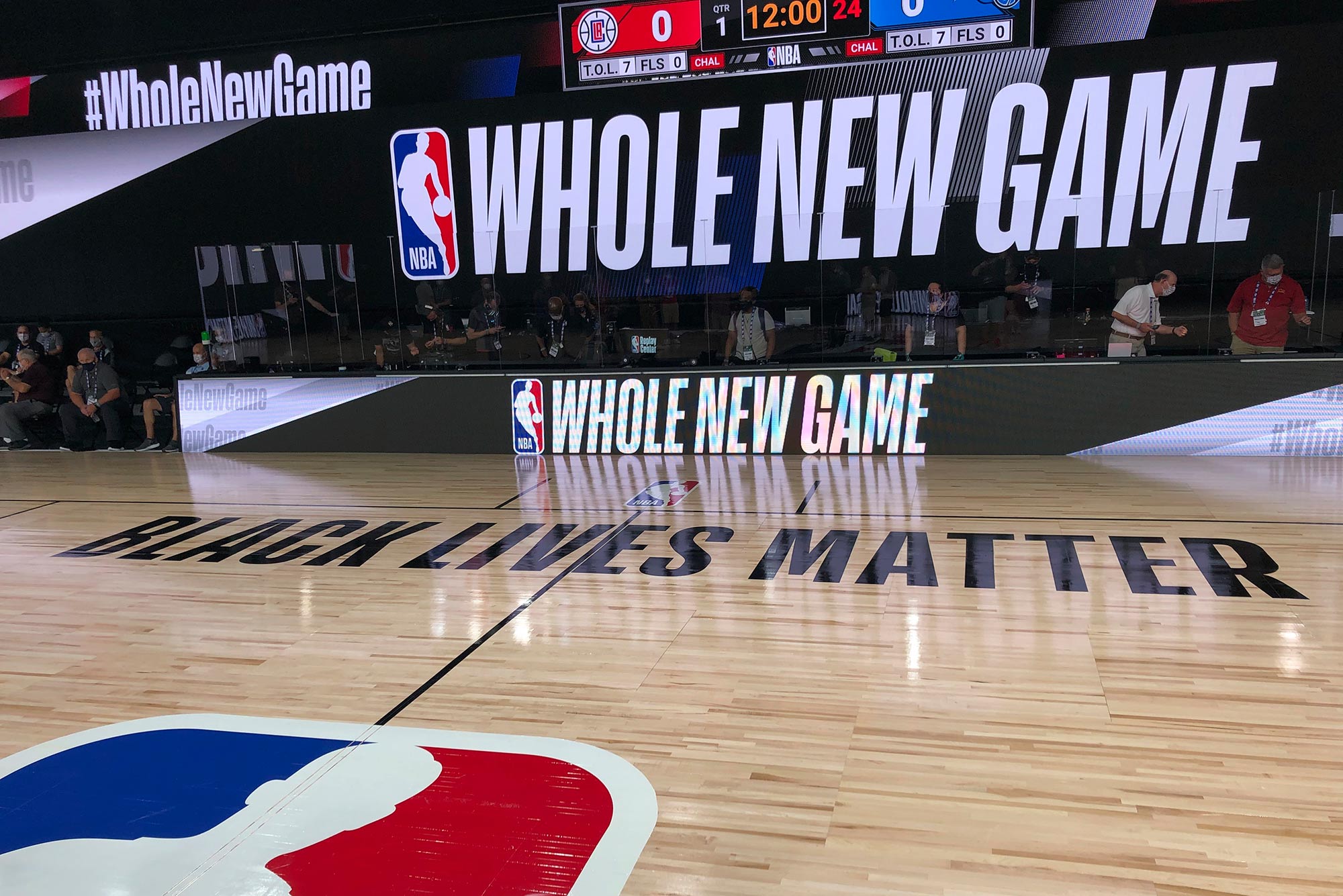 A basketball court is shown at the ESPN Wide World of Sports complex in Kissimmee, Fla., Tuesday, July 21, 2020. NBA's marketing motto for the restart of the season at Walt Disney World is “Whole New Game,” which is written on a television screen and banner near the court. The court parquet floor reads "Black Lives Matter"