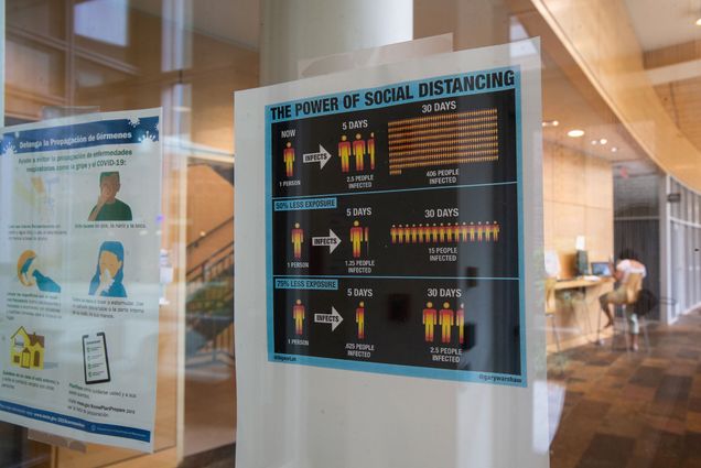 Signs advise COVID-19 precautions at the Fenway Campus, which will house undergraduate students who test positive for the novel coronavirus, per BU’s mandatory testing protocols. Signs use human figures to show the benefits of social distancing.