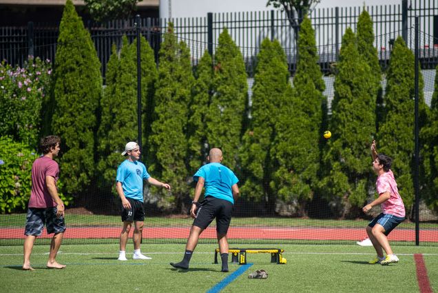A group of students playing spikeball outside on campus