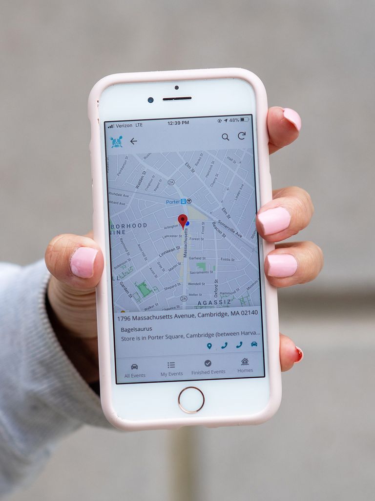 Photo of Flagg's hand holding a phone that shows the mobile app she developed for RLC home deliveries. Volunteers can use the app to contact donors, recipients, and alternates, as well as navigate to pick-up and delivery sites. The screen shows the map with a pin on it.