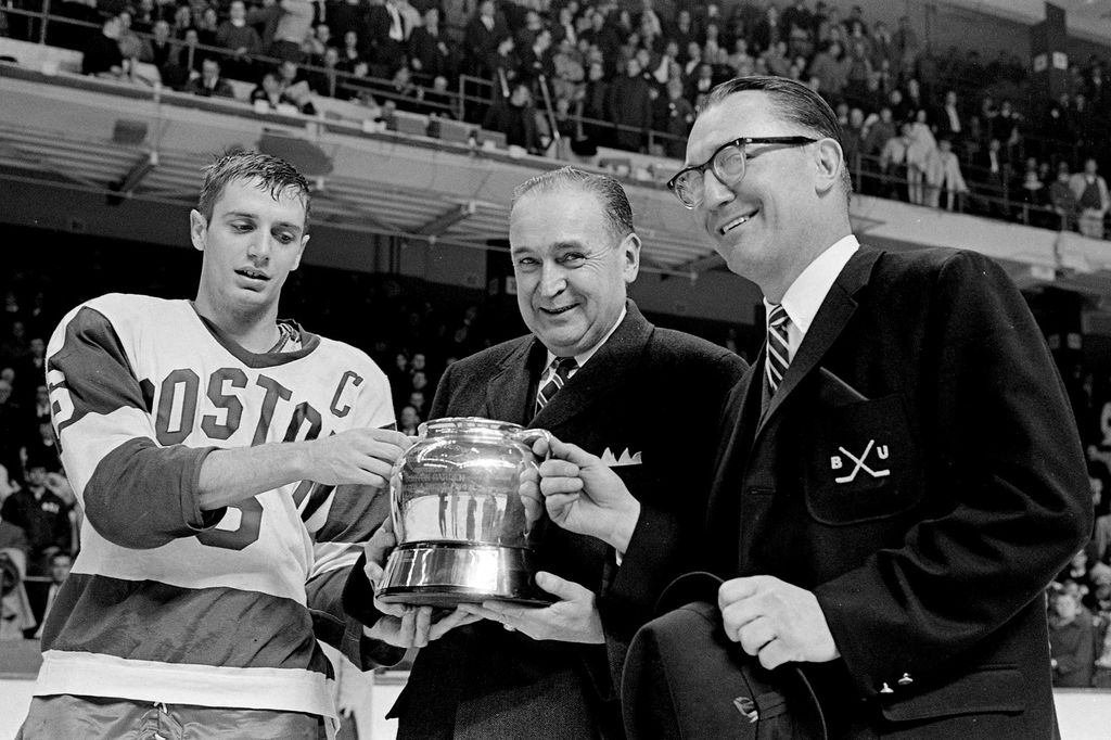 Black and white photo of BU Captain Jack Parker & Coach Kelley receiving the Beanpot Trophy after beating Harvard in 1968.