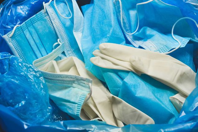 PPE discarded in medical waste bin