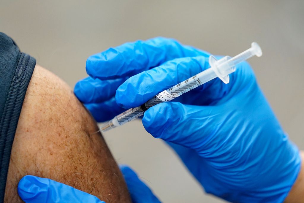 A photo of a vaccine being administered into someones arm