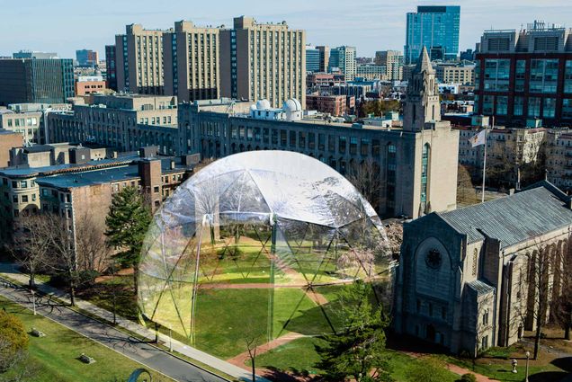 A humorous, photo-shopped image in which the BU Beach is covered with a plastic dome, like those seen around outdoor dining tables. The photo appears to have been taken by a drone over Storrow drive and captures Marsh Chapel and the Boston skyline on a sunny day.