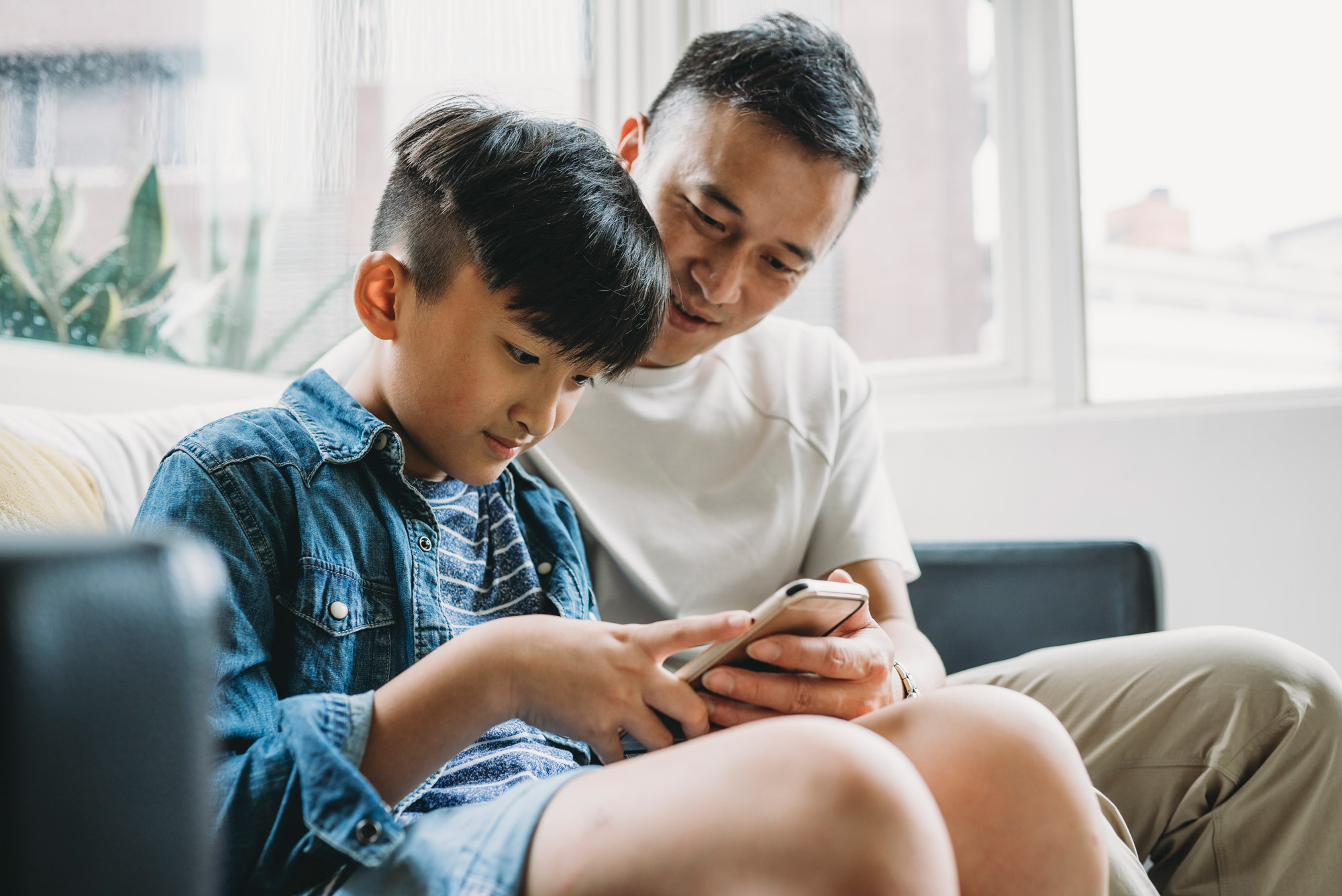 A photo of a father and son working together on a tablet