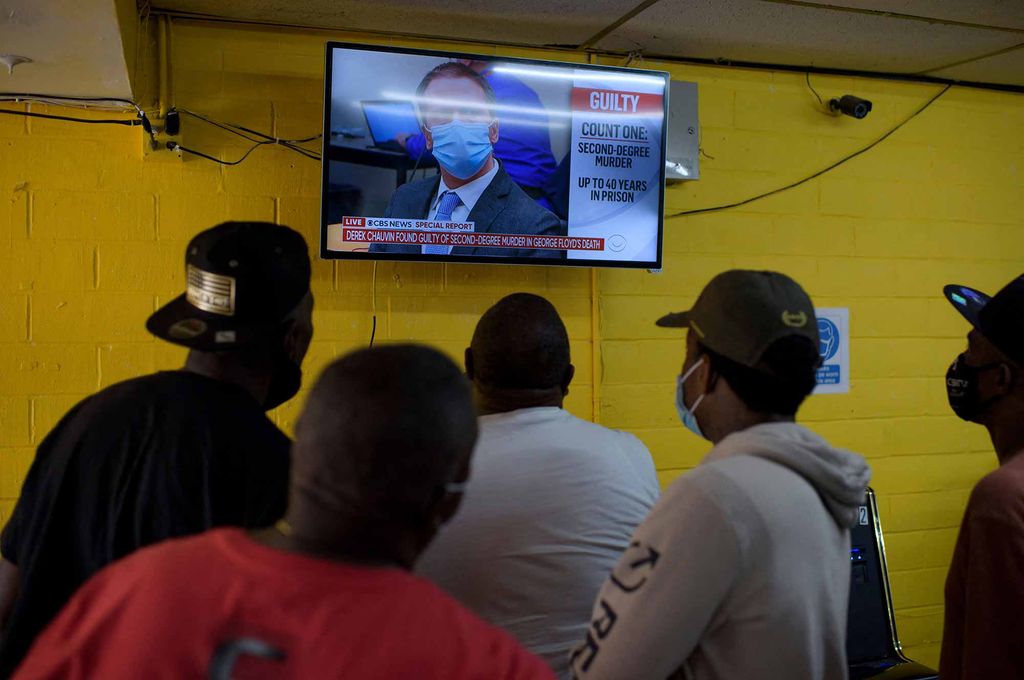 A crowd in Twees Foods convenience store in Houston, Texas gathers around a television to watch the verdict announced in the Derek Chauvin trial.