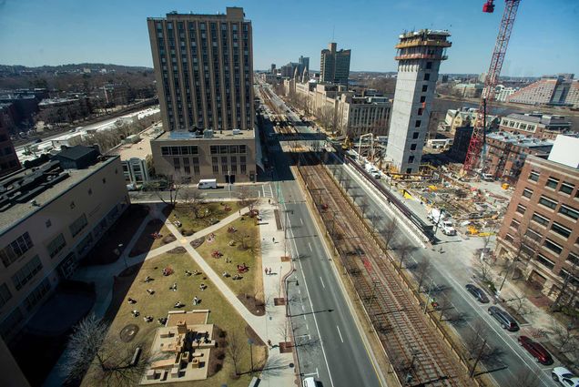 Photo taken from the top floor of Kilachand Center which shows the he Data Science Center Construction, at right, and the COM lawn onMarch 23. The lawn is yellowish green, as the grass has just begun growing, and the sky is clear blue.
