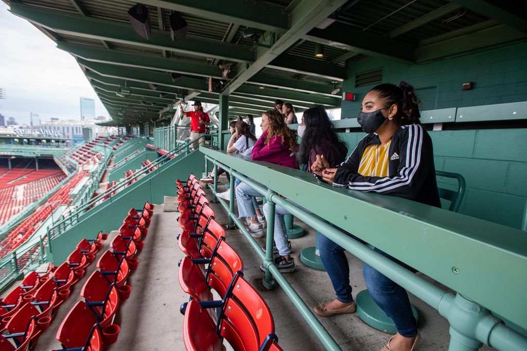 Maisha Miah (CGS’22,CAS’24), at right, looks over the field during a tour of Fenway Park. She wears a black adidas sweater.