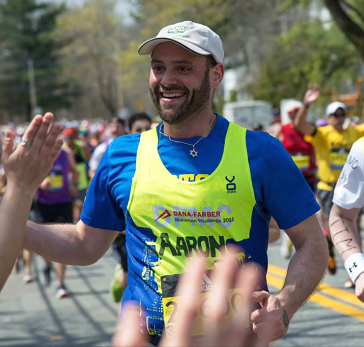 Aaron Stevens slaps the hand of a spectator while running the Boston Marathon.
