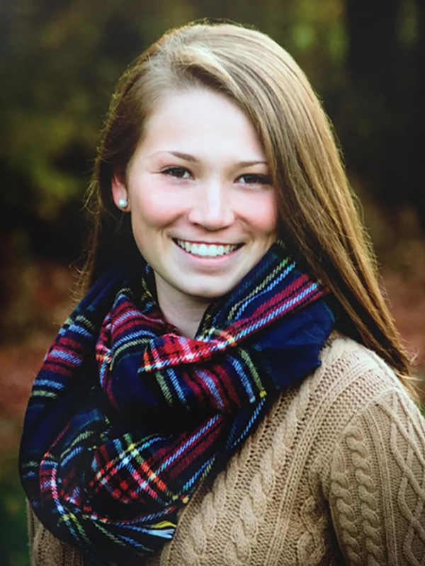 Photo of Hailey Hart-Thompson (CAS’21, COM’21) wearing a plaid scarf and tan sweater. She has blonde hair and smiles.