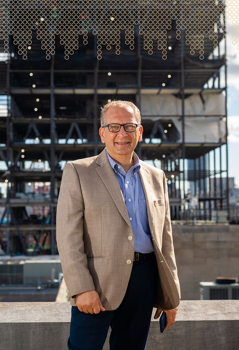 photo of Azer Bestavros, BU’s inaugural associate provost for computing and data sciences. He smiles and stands in front of the construction of the Data building.