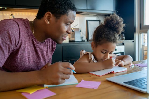 photo of a Black father helping and supporting his black daughter in their modern home