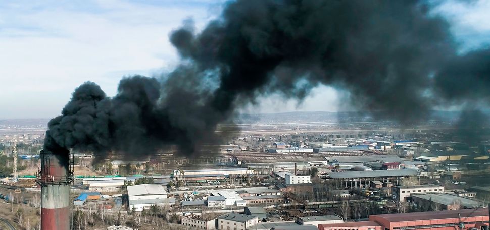 smoke spews out of a coal power plant smokestack in an unknown location