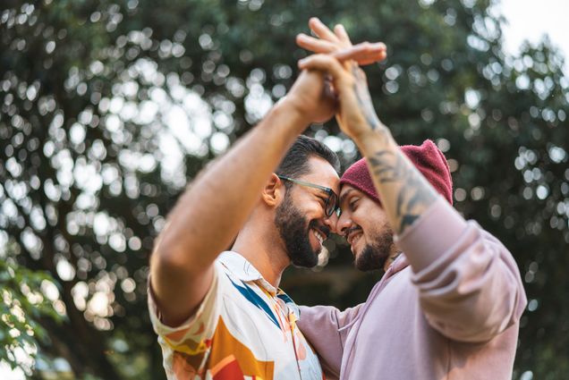 photo of two men holding hands and staring into each others eyes.
