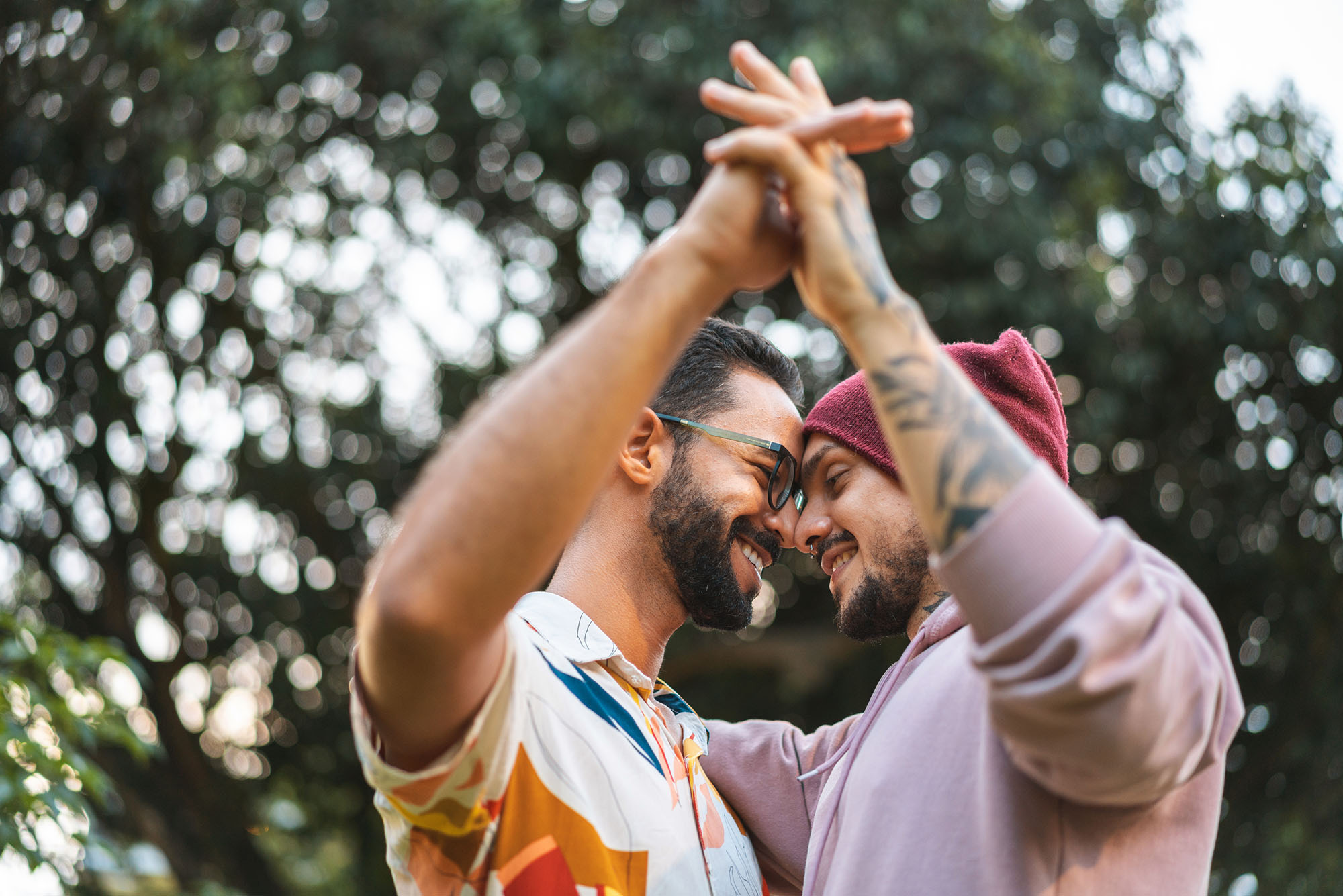 photo of two men holding hands and staring into each others eyes.