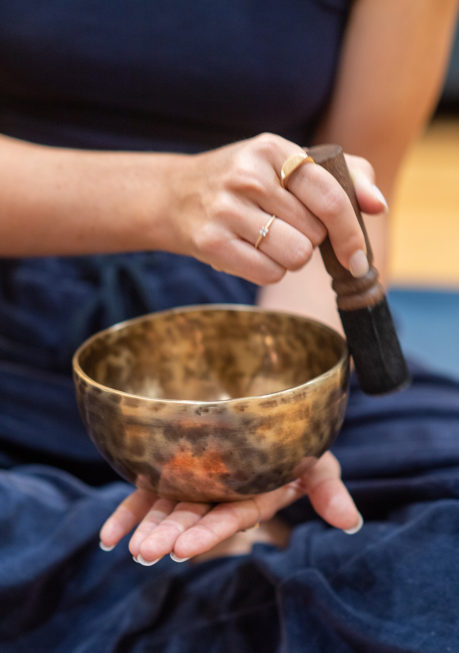 A photo of a singing bowl being held and played.