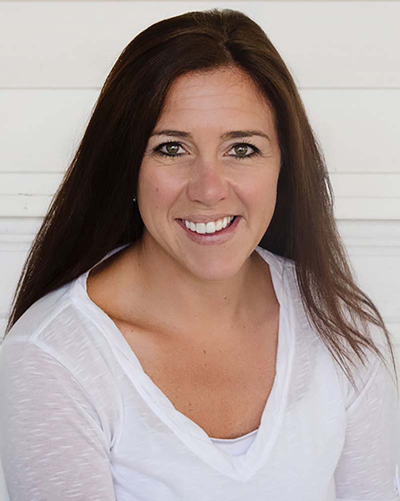 Photo of Jessica Harney, president of New England Disabled Sports, a white woman with long brown hair who smiles and wears a white t-shirt on a white background.
