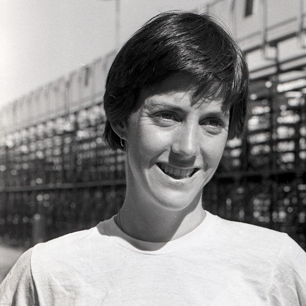 Portrait of Women's Cross Country Coach Joan Benoit on September 10, 1981. Photograph of a white woman with a bob hair cut that was taken on the track.