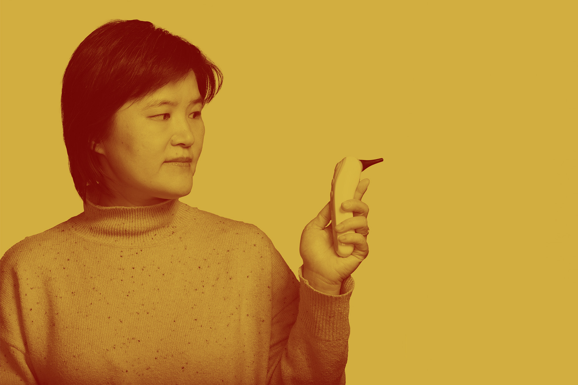 Alum Jane Zhang, co-founder and CEO of Remmie Health holds the ear infection detection device she designed. Photo by Ron Wurzer for Boston University Photography