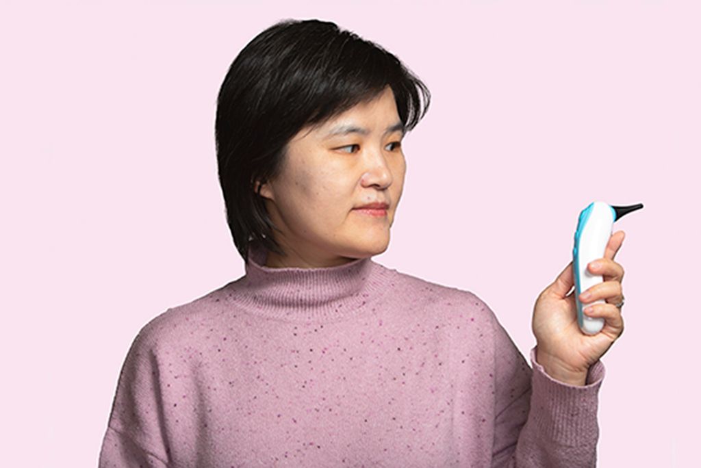 Alum Jane Zhang, co-founder and CEO of Remmie Health holds the ear infection detection device she designed. Photo by Ron Wurzer for Boston University Photography