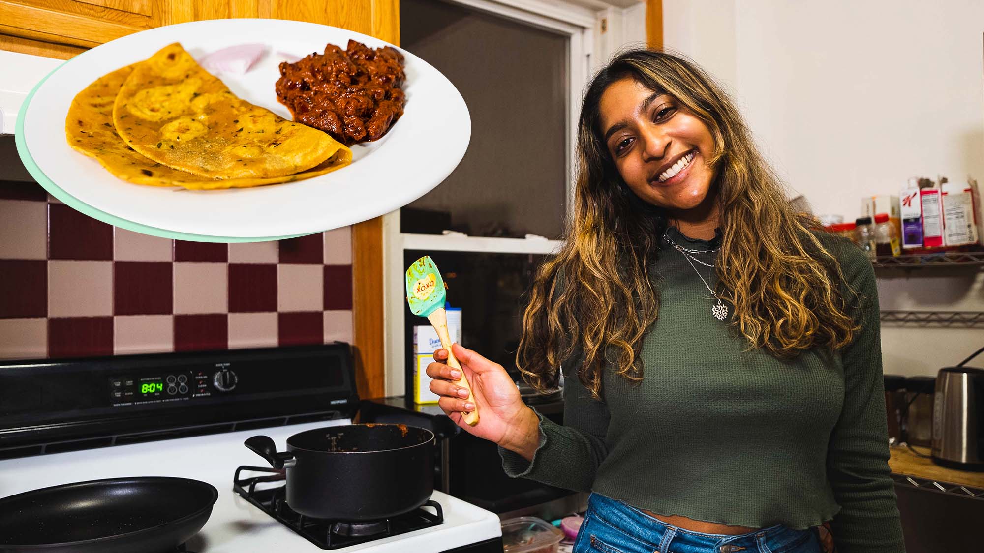 Photo of Neytra, a young Indian American woman with light brown skin and long brown, highlighted hair. She wears a green sweater and holds a spatula in her right hand. Behind her, you can see two black pots on a stove and a kitchen backsplash. At the top left of the photo is an image of the dish she cooked: curry made with red kidney beans and pureed tomatoes and flavored with spices like cloves, tumeric, and cinnamon with a side of roti.