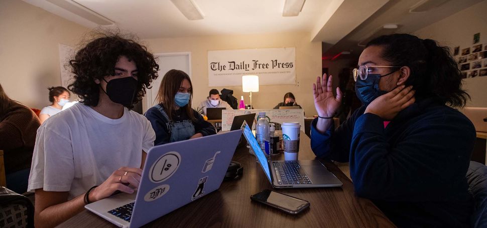 Photo of Campus editor Jesus Marrero Suarez (COM’24), from left, reporter Emilia Wisniewski (COMN’25), and associate campus news editor Tanisha Bhat (CGS’22,COM’24) during print night Feb 24 at The Free Press office. All the students wear masks and a white sign at the back of the room reads "The Daily Free Press"