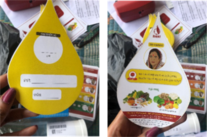 Photos: Left photo shows the back of a tear-shaped card that has 3 blank white boxes to write in information on a yellow background. The right photo shows the front of the card with illustrations of an Indian woman and various fruits and vegetables.