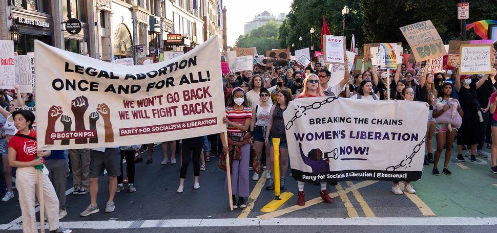 Photo of a large crowd of women holding signs protesting the SCOTUS Roe v. Wade decision at the intersection of Tremont Street and Boylston Street in Boston during the rally.