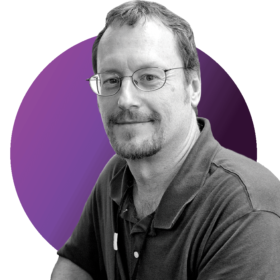 Black and white headshot photo of Boston University School of Medicine Professor Dr. Patrick McNamara. He sits and turns towards the camera wearing glasses and a short-sleeved collared shirt. Image is overlaid over a circle with gradient light purple to dark purple colors.