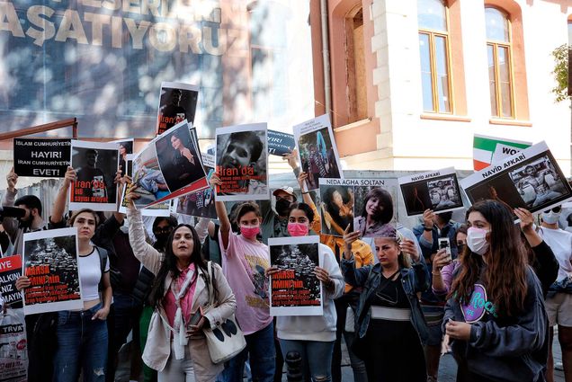 Photo: People hold signs and chant slogans during a protest over the death of Iranian Mahsa Amini outside the Iranian Consulate in Istanbul, Turkey, on September 26, 2022. A group of women, most not wearing hijabs, hold signs supporting Amini and protesting her death.