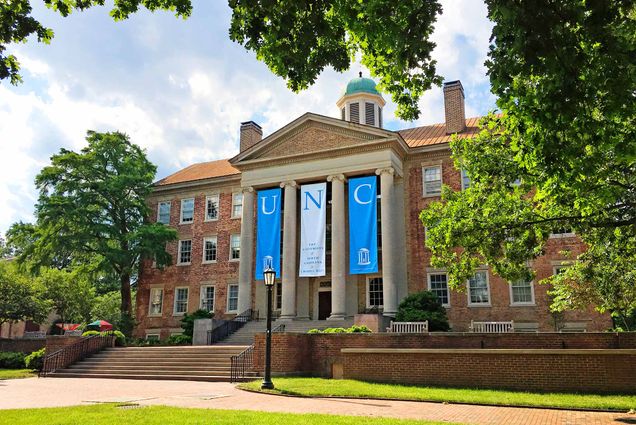 The South Building at The University of North Carolina at Chapel Hill in Chapel Hill, North Carolina is adorned with banners on a beautiful spring day.