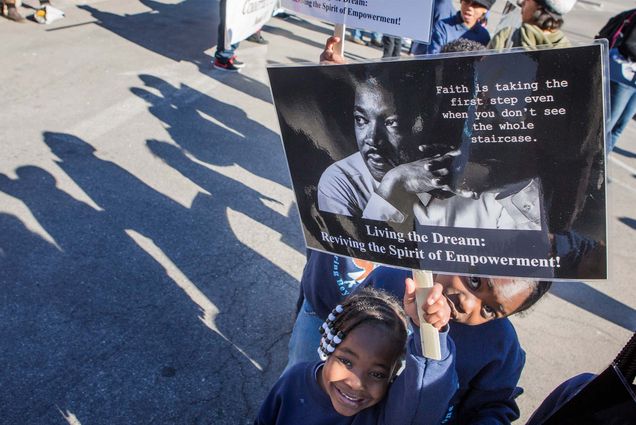 Photo: Students from Wendell Williams Elementary School hold an inspirational sign during the Martin Luther King Jr. parade in downtown Las Vegas, Monday Jan.16, 2017. A young Black girl with beaded twists smiles and holds up an MLK sign featuring his photo and a quote of his.
