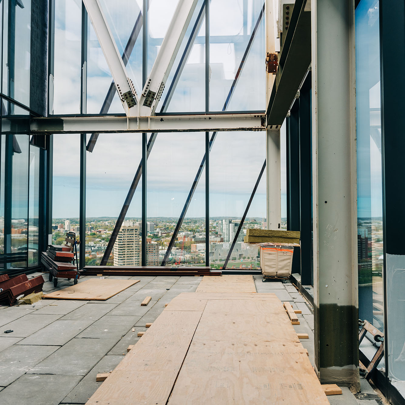 Photo: Interior room of the Center for Computing and Data Sciences building. A large wall of windows is shown in a room with unfinished floors.
