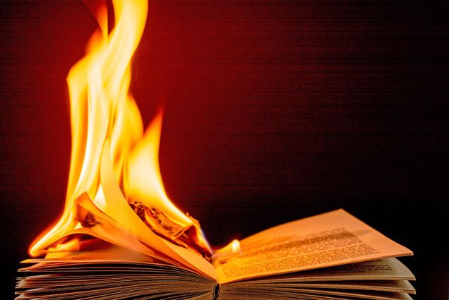 A book burning in front of a dark background