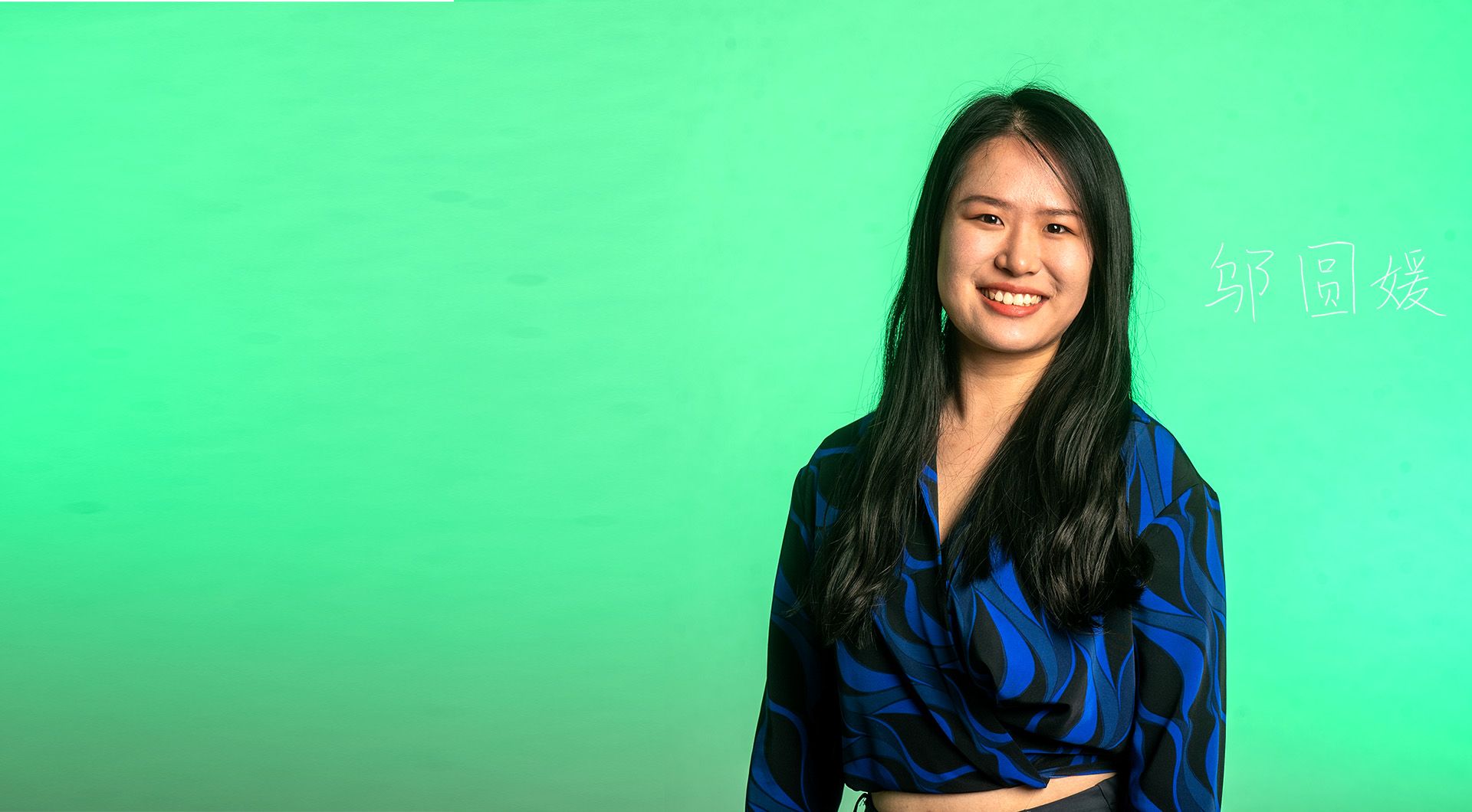 Photo: An Asian woman in a black and blue blouse is smiling into the camera.