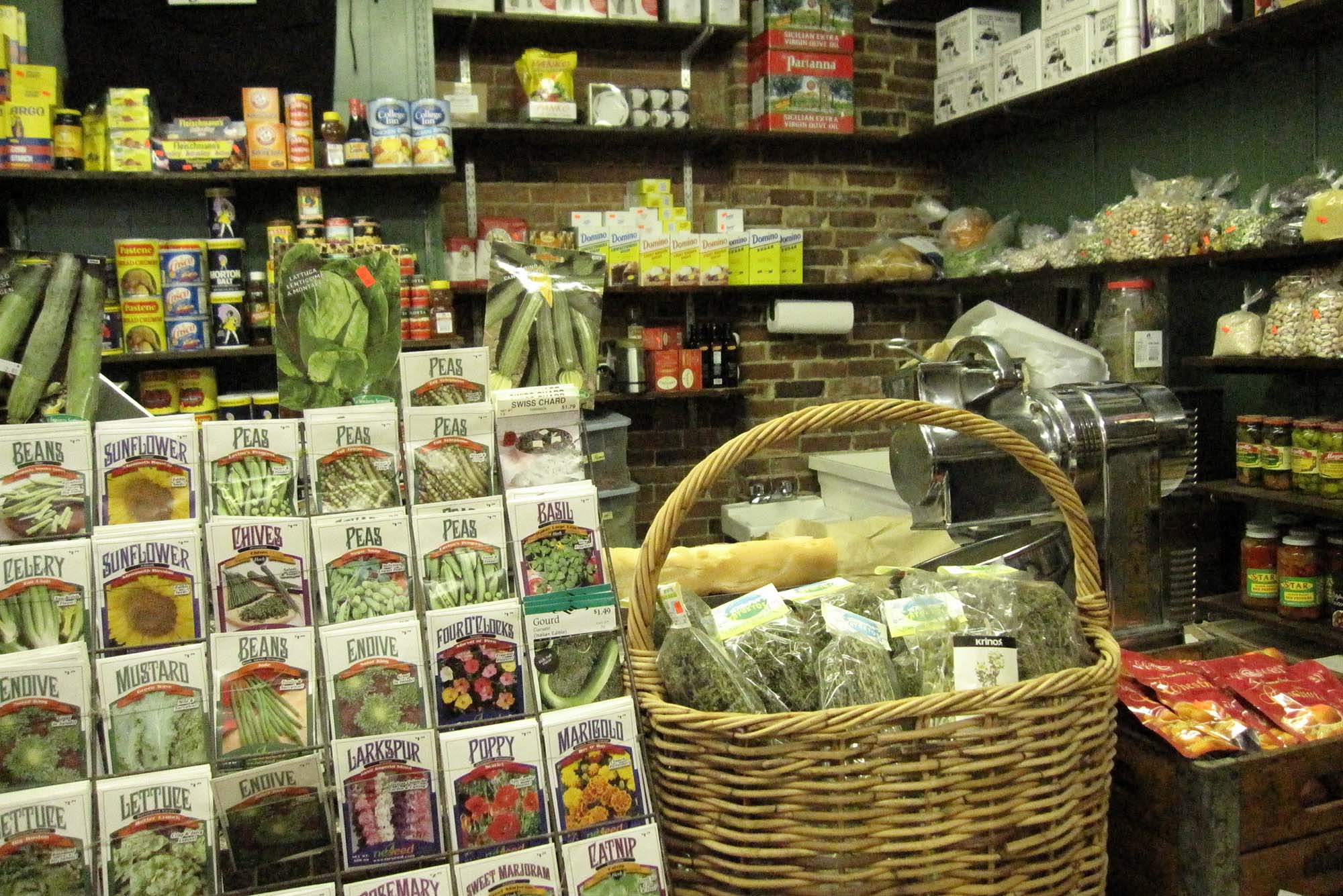 Photo: Packages of seeds and bags of spices in front of a coffee counter at Polcari's Coffee in Boston's North End