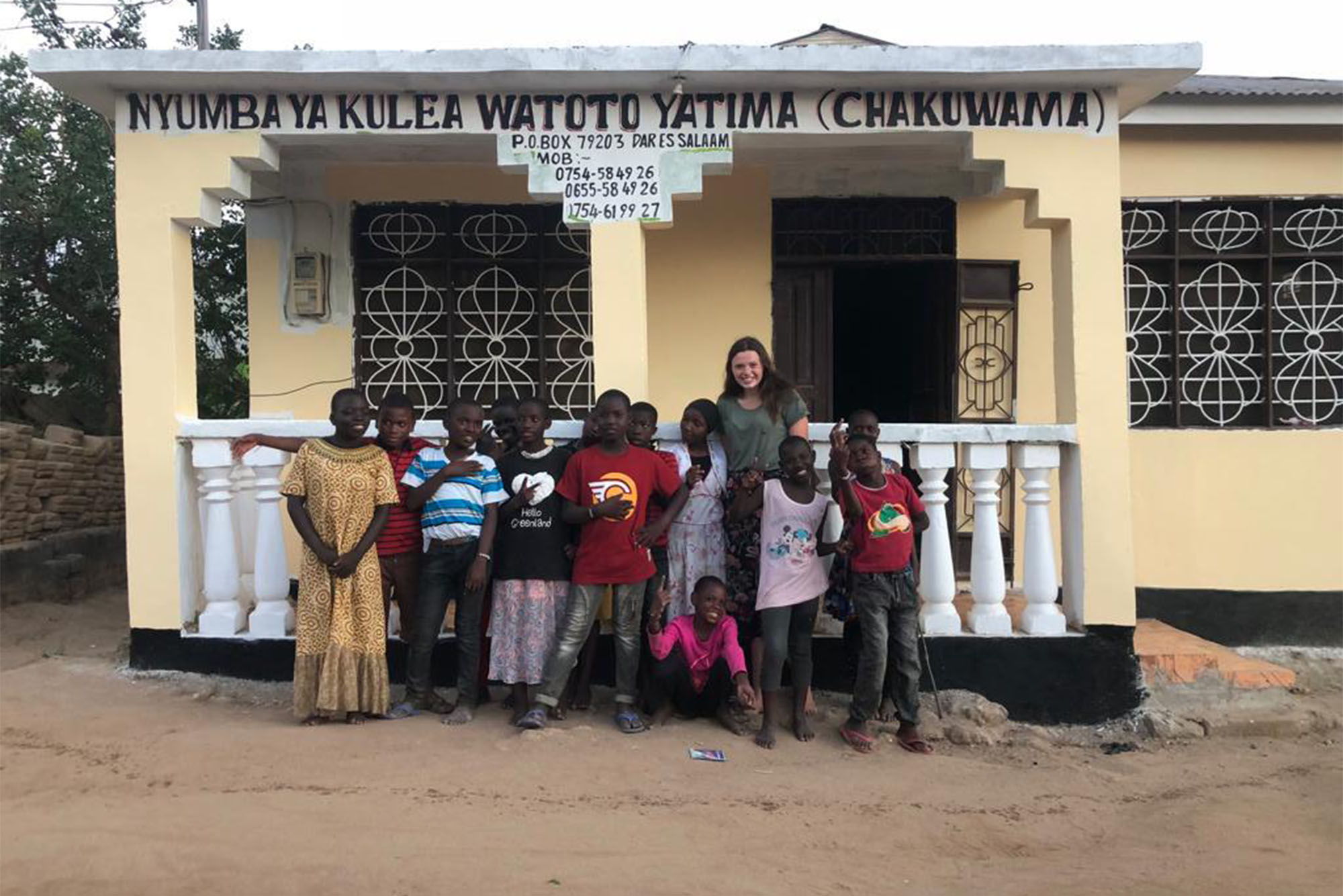 Photo: A group of people stand in front of a newly remodeled orphanage in Tanzania