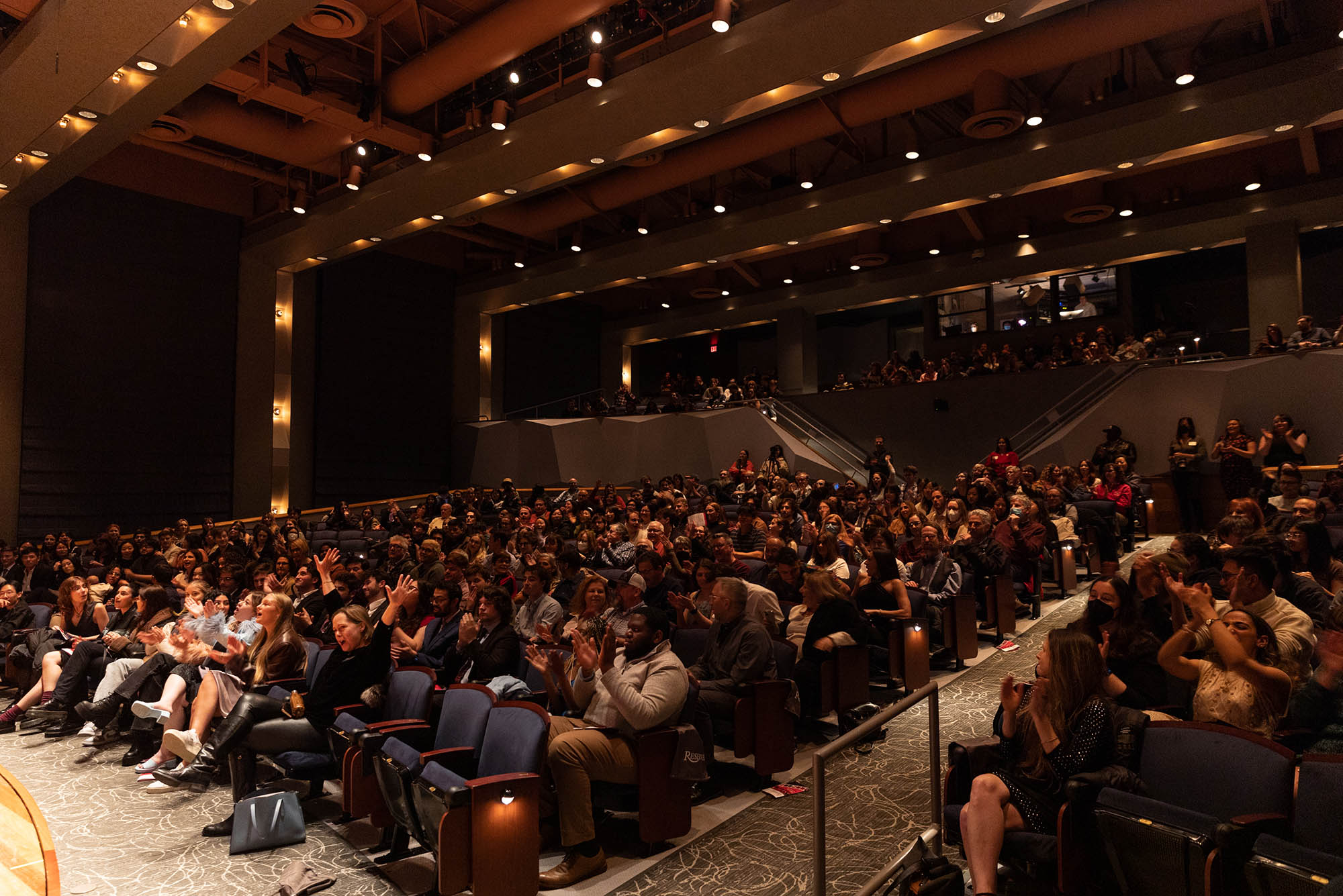 Photo: A wide shot of the sold-out audience at the Redstone Film Festival. Everyone is looking at the stage and have expressions of excitement on their face.