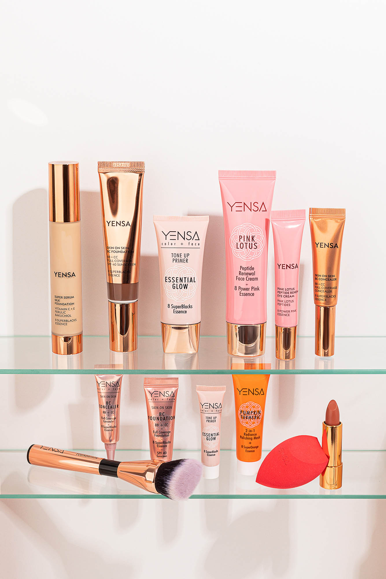 Photo: Eleven products on a glass shelf with pink and gold packaging.