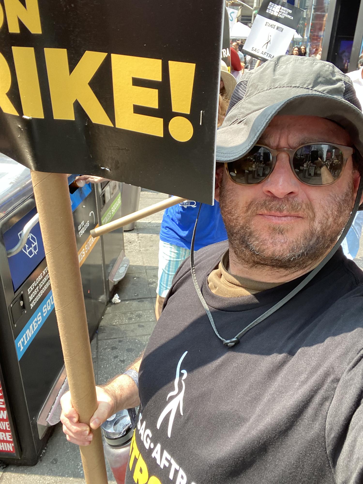 Photo: A white man, Dave Shalansky, holds up his picket sign for the SAG strike.