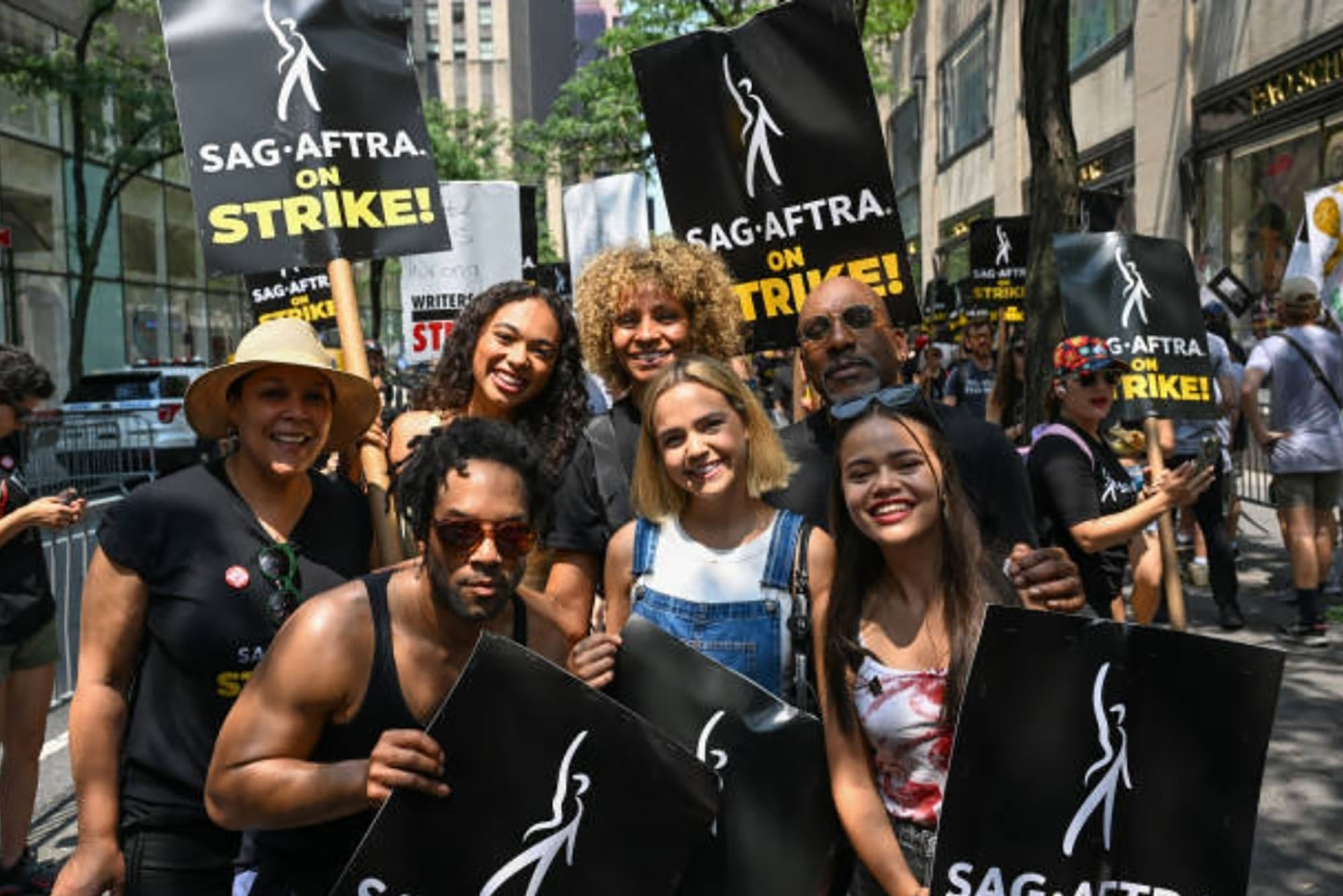 Photo: A group of actors pose for a photo while they hold up their picket signs for the SAG STRIKE.