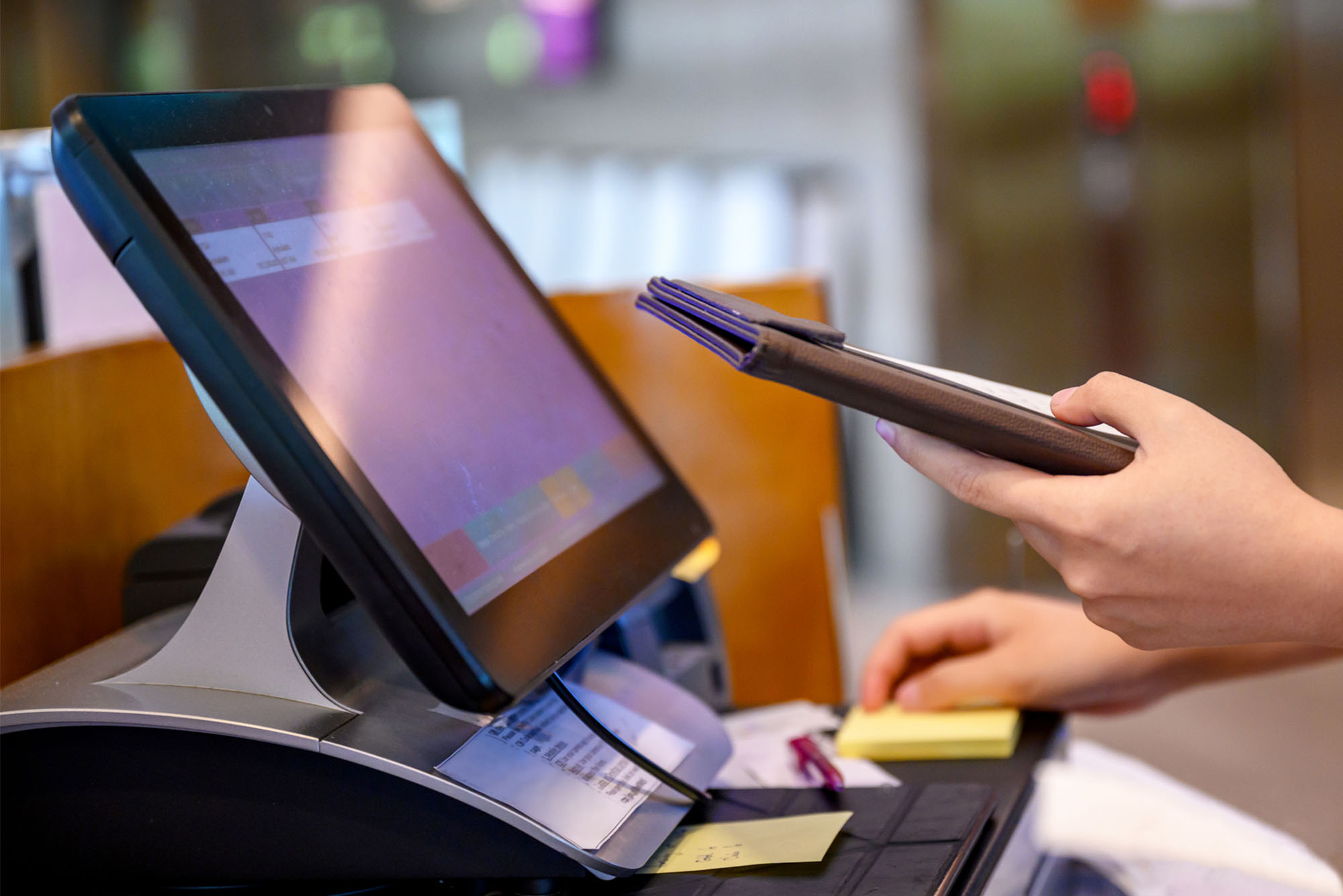Photo: A POS computer at a restaurant with someone's hand inputting orders on the screen