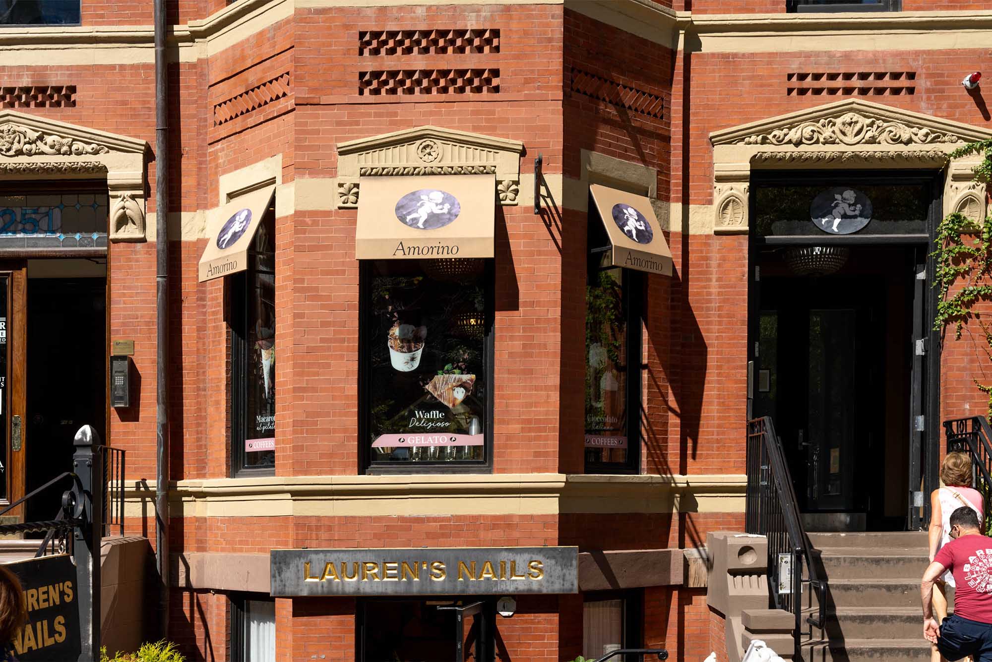 Photo: An ornate brick building with a wrought iron staircase railing has a banner reading "Amorino"