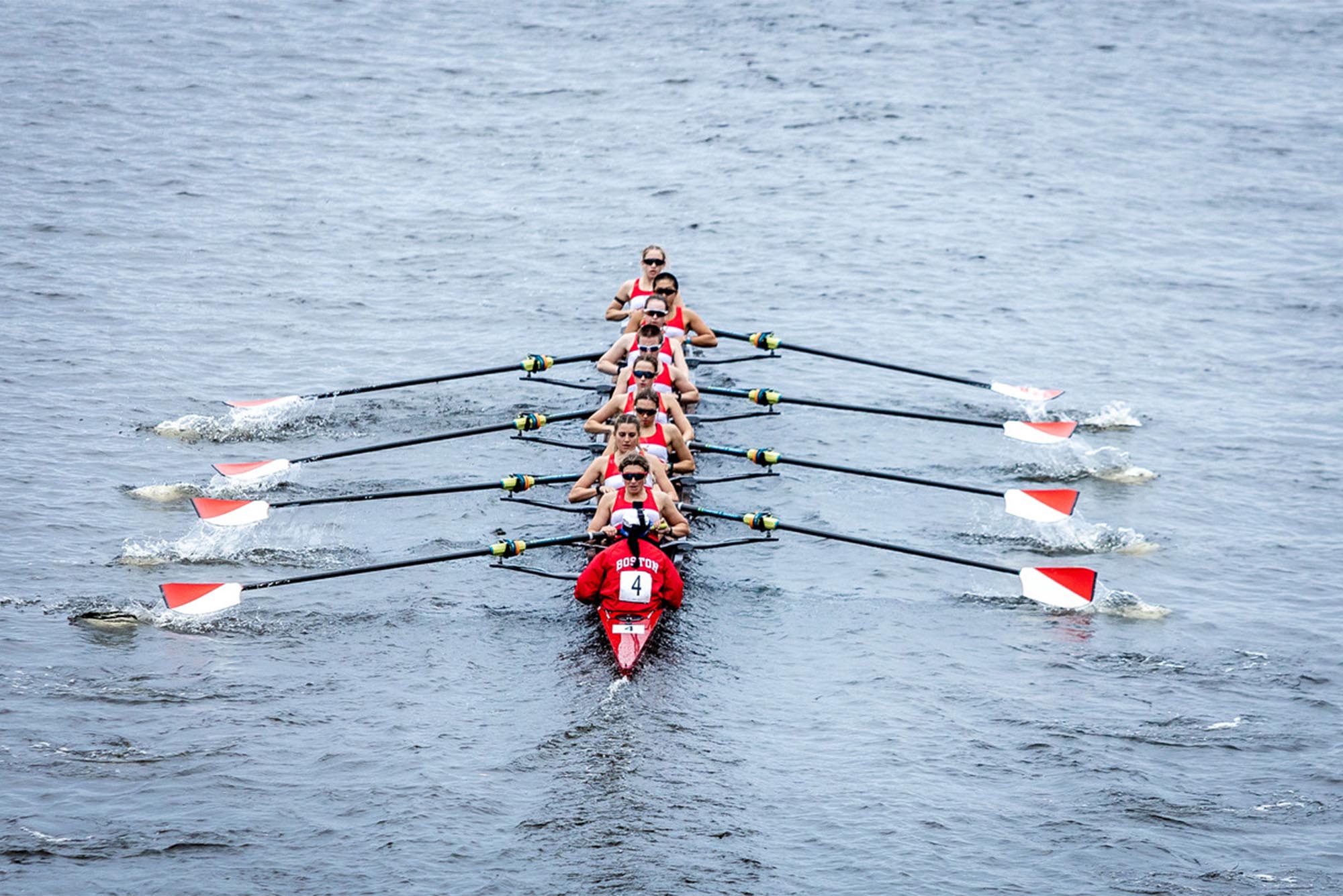 Photo: A group of athletes rowing a boat down a river