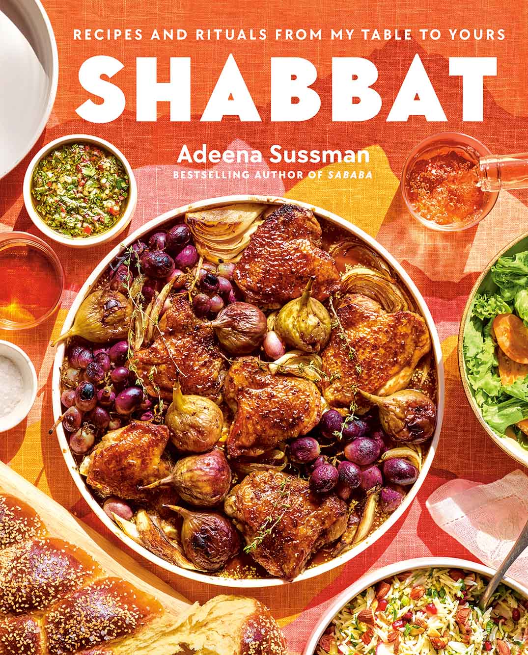 Cover of the cookbook "Shabbat" by Adeena Sussman. Cover shows an overhead shot of a one-pan dish of chicken, onions, and various vegetables all displayed on a colorful table setting. The word "Shabbat" is shown with white, bold font.