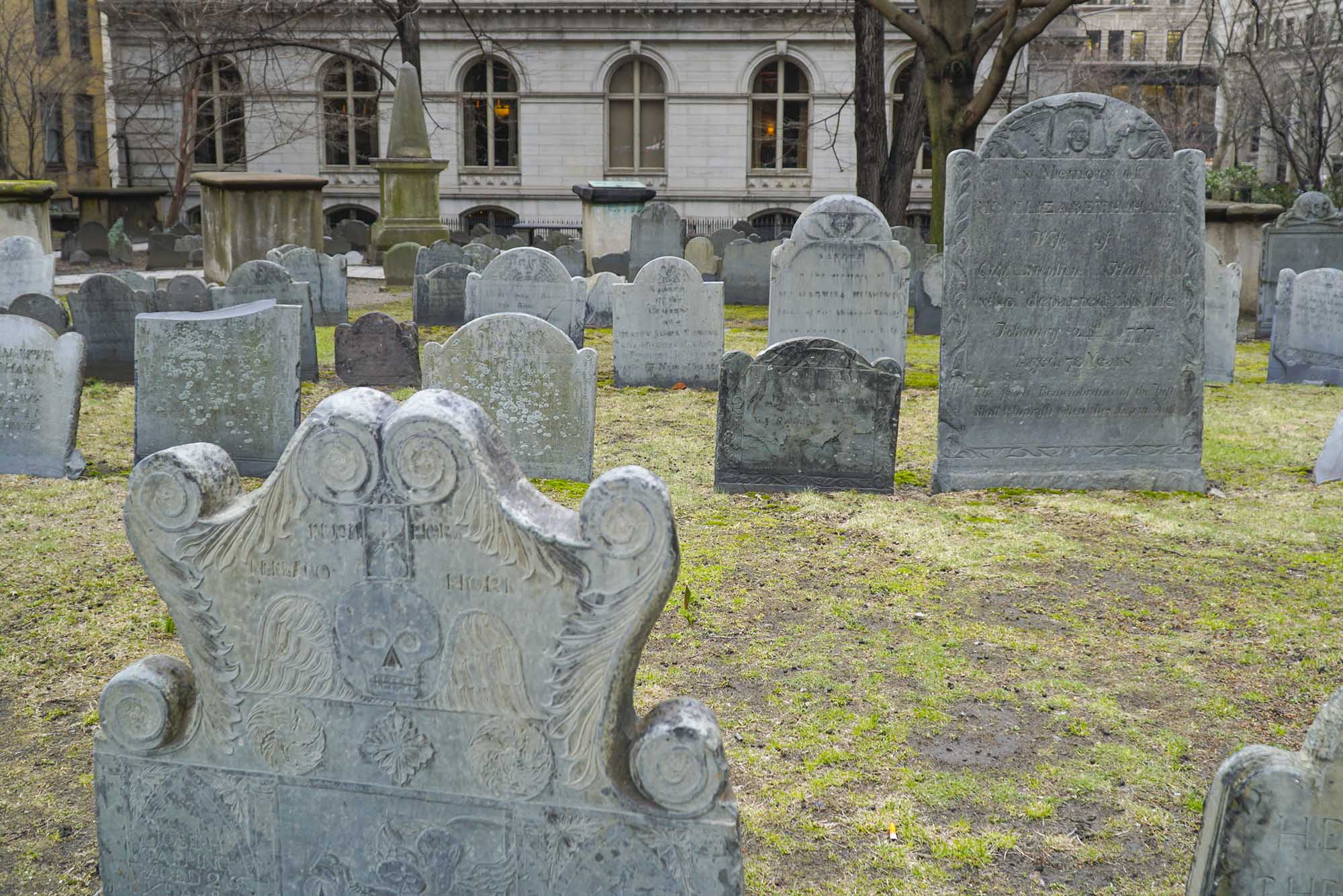 Photo: A stock image of a graveyard. The headstones are old and eclectic and the ground is patchy grass.