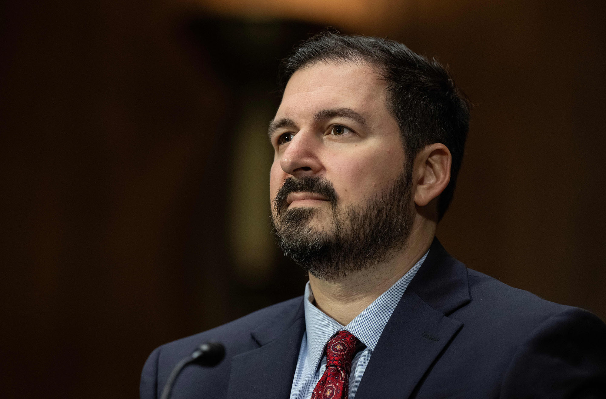 Photo: Woodrow Hartzog, Professor of Law at Boston University School of Law, looks on prior to a Senate Judiciary Subcommittee on Privacy, Technology, and the Law oversight hearing to examine legislating artificial intelligence (AI), on Capitol Hill in Washington, DC, on September 12, 2023. A white man with dark brown hair and beard and wearing a black suit, light blue collared shirt, and dark red tie, looks to the left.