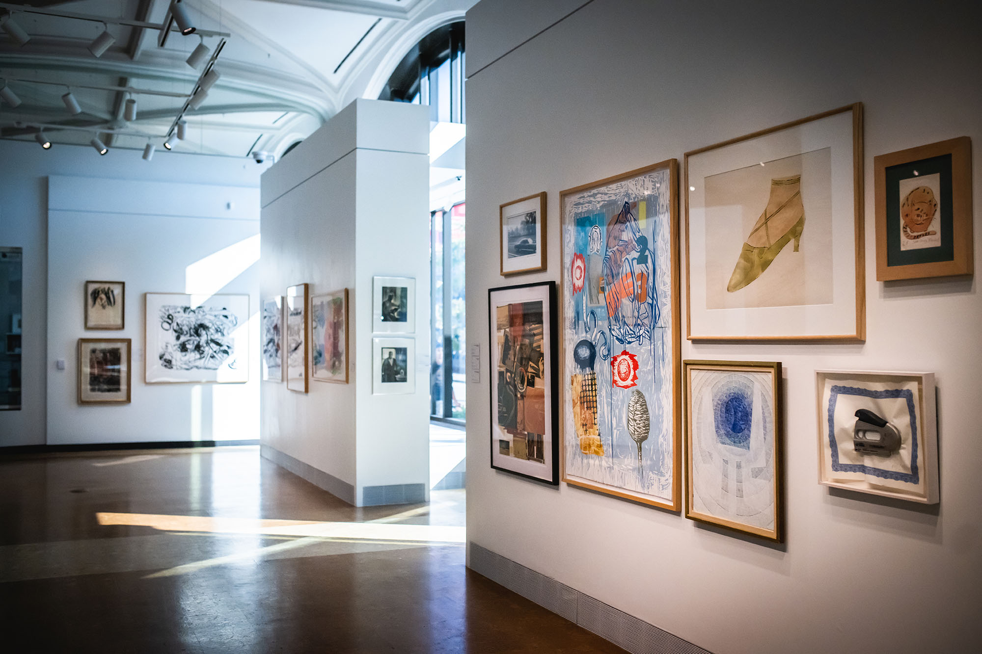 Photo: The interior of an art gallery is shown. Various pieces of Andy Warhol's art is displayed on large white walls as sunlight streams in through large windows.